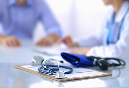 Doctor woman sitting with  male patient at the desk