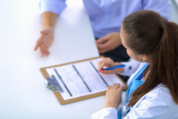 Doctor woman sitting with  male patient at the desk