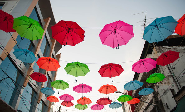 Streets are decorated with colorful umbrellas.
