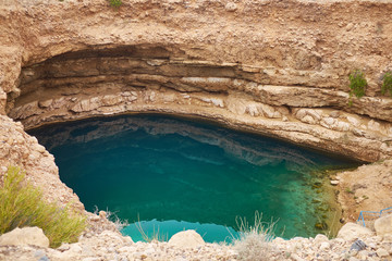 Sinkhole with emerald green water at Hawiyat Najm Park, Oman