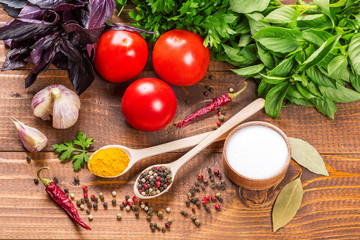 Raw vegetables, basil and spices on the wood table