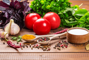 Raw vegetables, basil and spices on the wood table