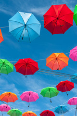 Streets are decorated with colorful umbrellas.
