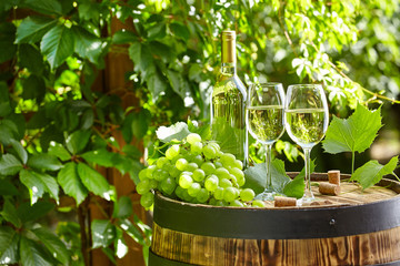 The glass of wine an and old barrel and grape