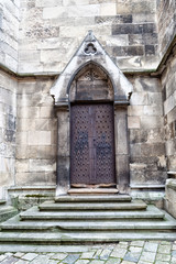 Wrought iron vintage door and stone steps of the church.