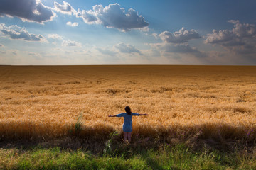 Girl among a field of wheat
