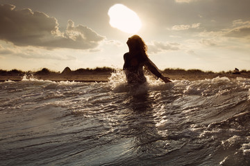 Young woman on sea embracing the the world and the waves © danmir12