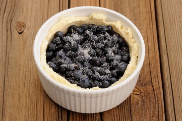 Fototapeta na wymiar Raw homemade round open pie with whole wild blueberries with sug