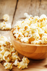 Sweet caramel popcorn in a wooden bowl, selective focus