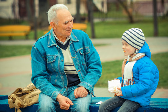 Grandfather And Grandson Eating Fries And Indulge