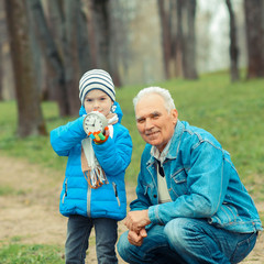 Fototapeta premium Grandfather showing grandson vintage watches. The grandfather tells his grandson about time.