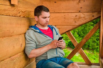 Young man using mobile phone. Mountains. Communication concept. 