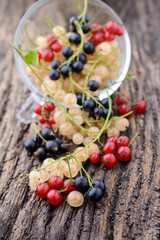 Currants in a transparent cup on the old wooden table
