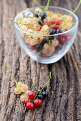 Currants in a transparent cup on the old wooden table