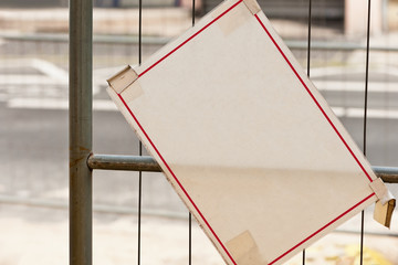 Ein unbeschriftetes weisses Schild hängt schief am Zaun