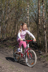 Fototapeta na wymiar little girl rides a bicycle