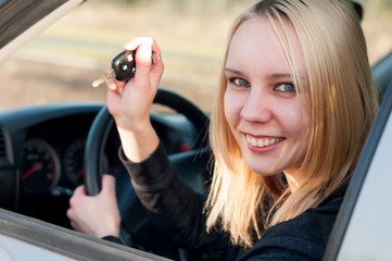 Happy student girl with key from her new car