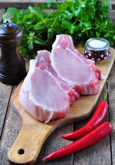 raw pork chop on the bone with parsley, mint, pepper and sea salt