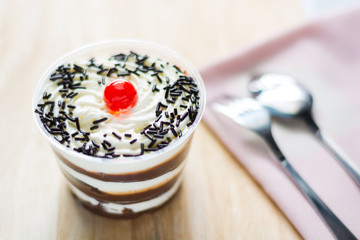 Cake of fresh milk in plastic cups delicious decorated with whip