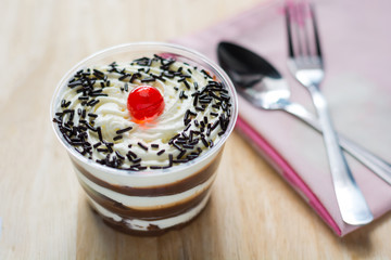 Cake of fresh milk in plastic cups delicious decorated with whip