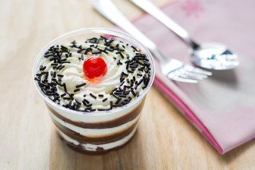 Cake of fresh milk in plastic cups delicious decorated with whip