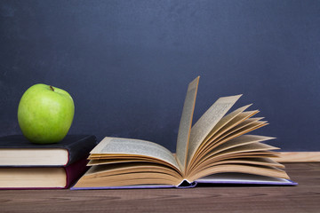 blackboard, books and apple on desk