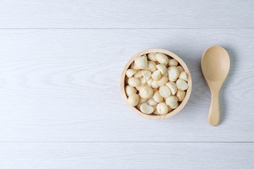 Top view macadamia nuts and shell in wooden bowl