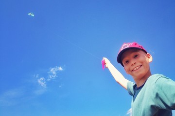 Szczęśliwy chłopiec puszcza latawca - obrazy, fototapety, plakaty