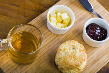 breakfast table with tea, teapot, cup of tea, jam, bread and hon
