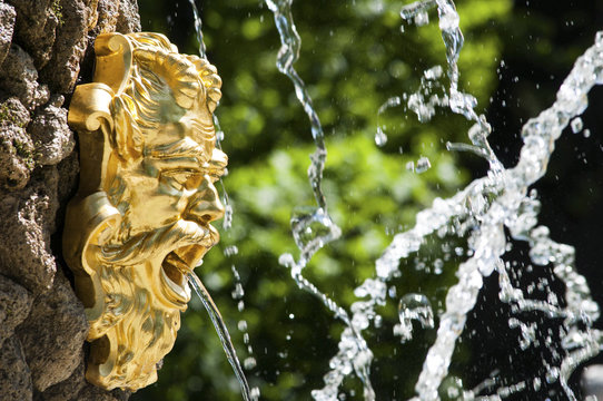 Golden fountain face of Neptune in the park