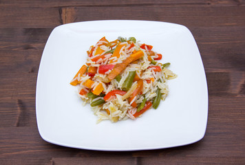 Rice with sauteed vegetables on wooden table