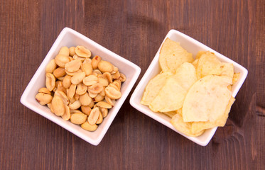 Square bowls of pretzels on wooden table seen from above