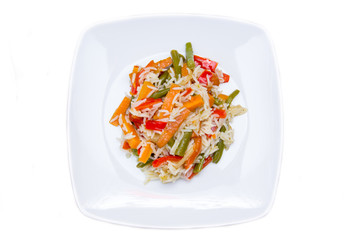 Rice with sauteed vegetables on a white background seen from above
