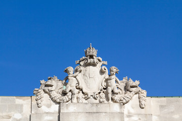 Obraz premium Ornamental baby angels holding a royal shield