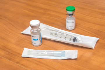 The syringe and needle in a pack next to the two ampoules for pr