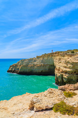 Lighthouse building on top of cliff on coast of Portugal near Carvoeiro town, Algarve region