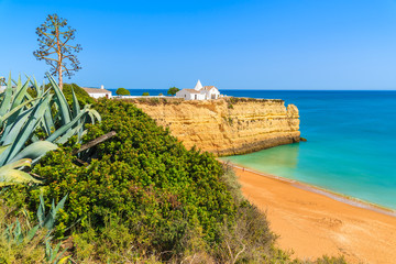White small church on top of cliff at Armacao de Pera beach, Algarve region, Portugal