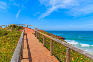 Obraz premium Wooden walkway to Praia do Amado beach and beautiful blue sea view, Algarve region, Portugal