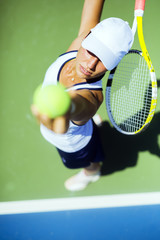Beautiful female tennis player serving - obrazy, fototapety, plakaty
