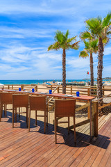 Chairs on terrace of a restaurant on Armacao de Pera beach in Algarve region, Portugal