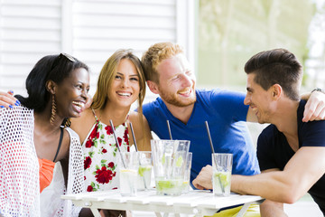Happy young people laughing a being happy at a table