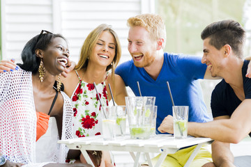 Happy young people laughing a being happy at a table