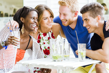 Happy young people laughing a being happy at a table