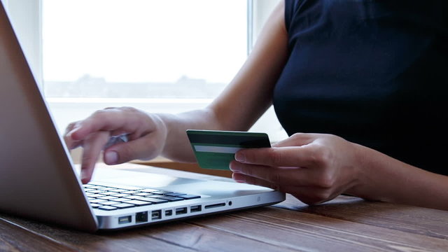 Paying with credit card online on wooden desk