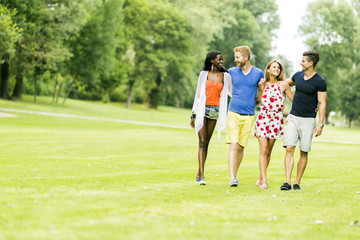 Fototapeta premium Cheerful friends walking in a park and having a good time