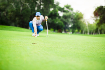 Obraz premium Golf player marking ball on the putting green