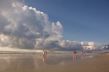 people walking on the beach and cloud