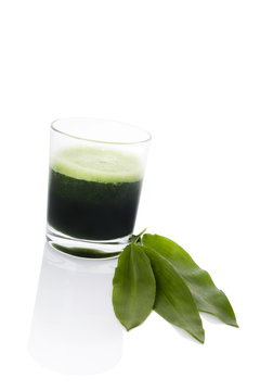 Green juice in glass isolated.