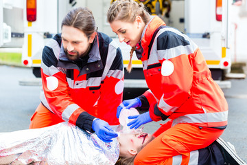 Notarzt und Sanitäter beatmen Unfallopfer 