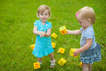 Little girls on nature playing toy